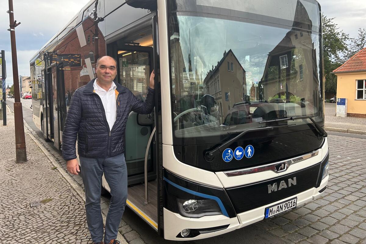 ORP-Geschäftsführer Ulrich Steffen neben einem Elektrobus, der vom Hersteller zur Verfügung gestellt wurde. Ab 2025 sollen zehn elektrisch betriebene Busse im Raum Wittstock/Dosse regelmäßig zum Einsatz kommen. © LK OPR