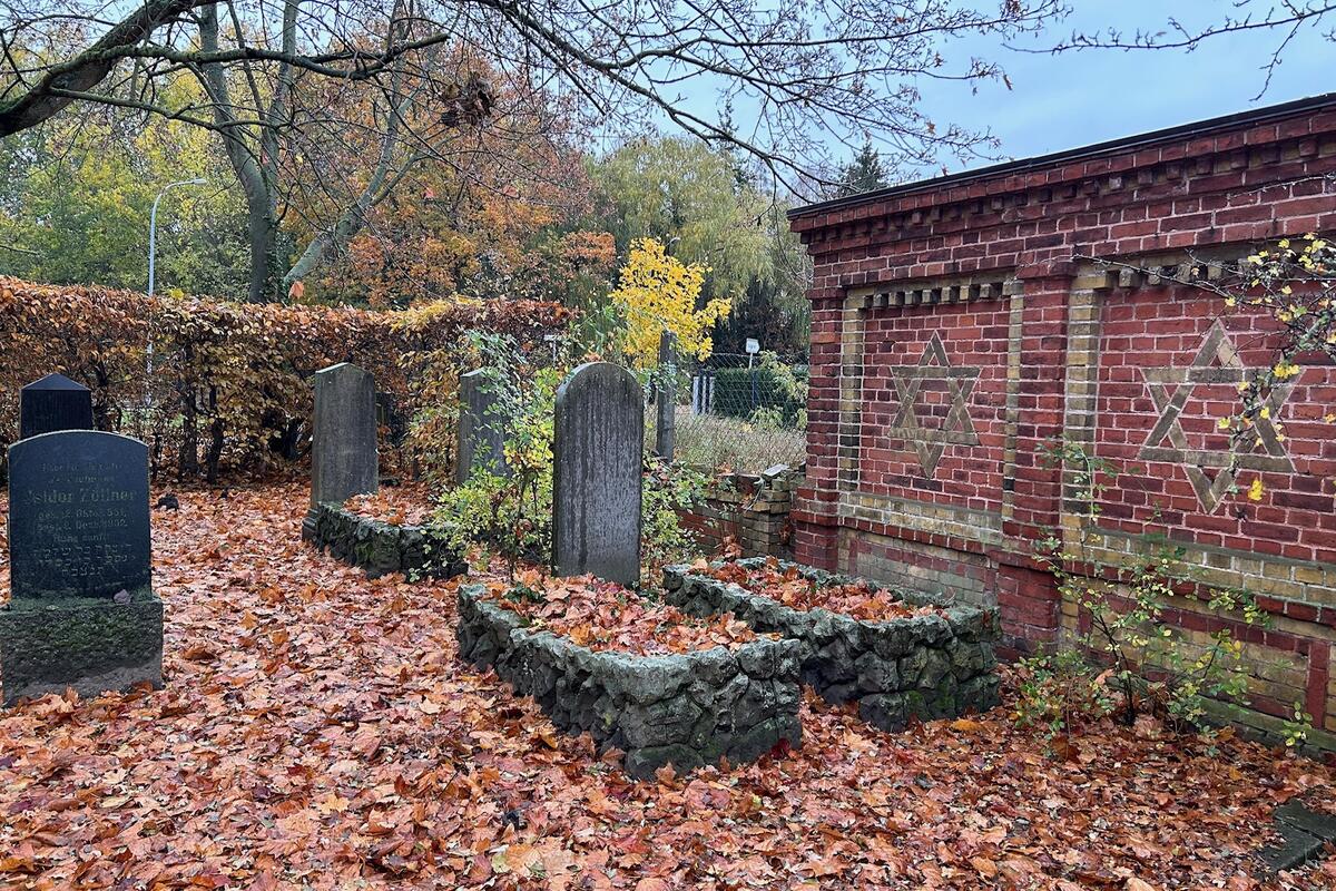 Reste der Mauer sowie Gräber des jüdischen Friedhofs in Neuruppin. Der alte Begräbnisplatz hinter dem Weinberg wurde 1935 von den Nationalsozialisten konfisziert und die Gräber auf den neuen Friedhof überführt. © LK OPR